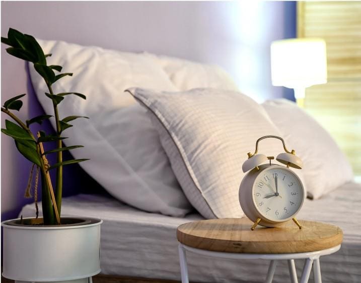 Reloj en la mesilla junto a la cama